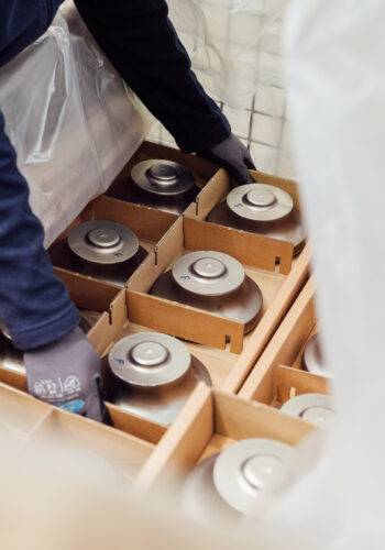 An employee unpacks raw materials for turbocharger wheels.